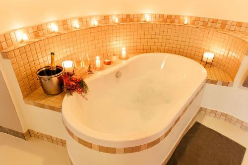 兰斯堡塔姆布特小屋酒店的浴室配有带蜡烛和灯的浴缸。
