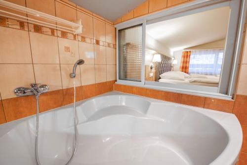 斯米扎尼斯洛伐克拉吉辛格夫酒店的带浴缸的浴室和窗户
