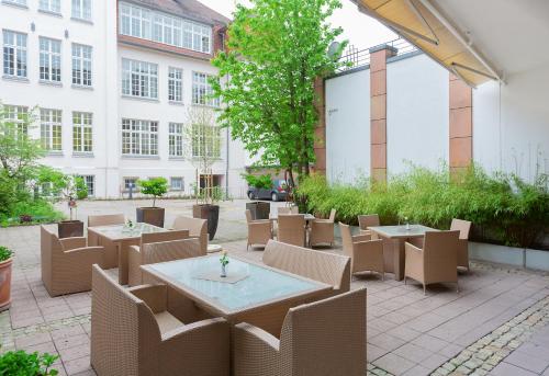 代特莫尔德Residenz Hotel Detmold的一座配有桌椅的庭院和一座建筑