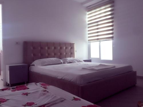 奥里库姆Eriola apartament的一间卧室设有两张床和窗户。