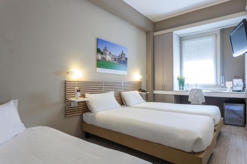 都灵格兰莫格尔最佳品质酒店的酒店客房设有两张床和窗户。
