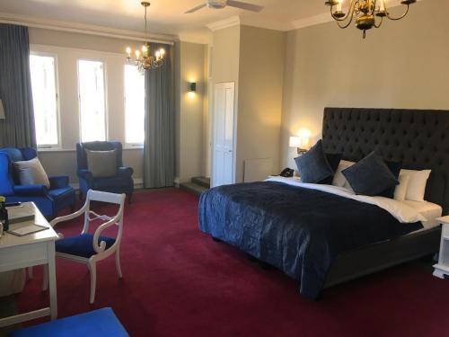 约翰内斯堡Rand Club Suites的一间卧室配有一张大床和一张桌子及椅子