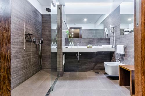 巴塔拉巴塔利亚别墅酒店的带淋浴、盥洗盆和浴缸的浴室