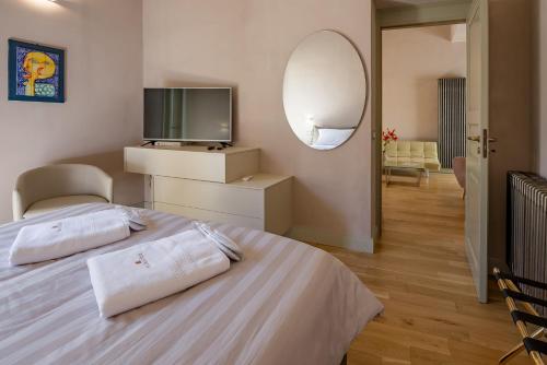 夏卡Cantine De Gregorio Suites的一间卧室配有一张带电视和镜子的床