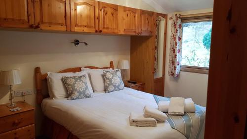 巴拉胡利什Birch Chalet的一间卧室配有一张大床和毛巾