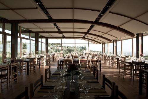 CoriCincinnato Wine Resort的宴会厅配有桌椅和玻璃杯