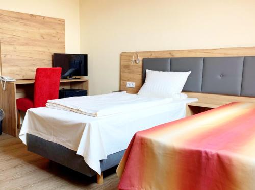 美茵河畔哈瑙Tur图恩翰瑙酒店的酒店客房,配有一张床和一张红色椅子