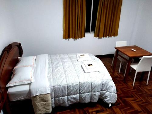 齐克拉约Santa Victoria House的一间卧室配有一张床、一张桌子和一张桌子