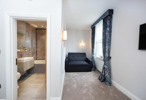 泰晤士河畔金斯顿金斯阿姆酒店的浴室设有黑椅和窗户。