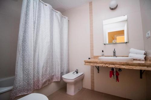 阿瓜杜尔塞Expoholidays - Apartamento con acceso directo a la piscina 1-D的浴室配有淋浴帘、卫生间和盥洗盆。