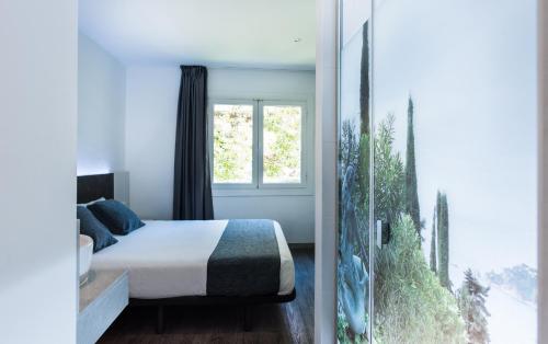 罗列特海岸里巴斯旅馆 的一间卧室设有一张床和一个大窗户