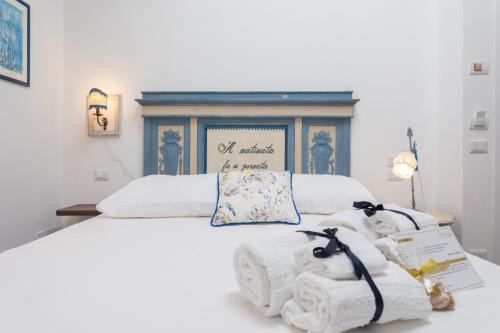 巴勒莫Addimora Boutique Suites的一张白色的床,上面有两只填充的动物