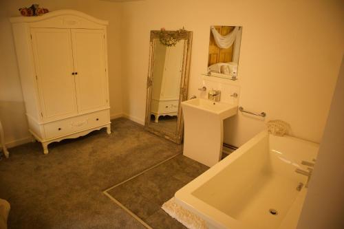 ShiltonMagna的一间带水槽、浴缸和镜子的浴室