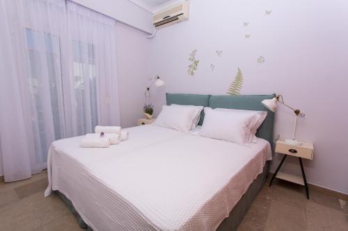 爱琴娜岛Afaia houses的一间卧室配有带白色床单和白色枕头的床。