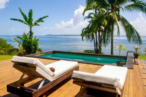 博卡斯德尔托罗El Caribeo的一个带椅子的甲板和一个游泳池,享有海景