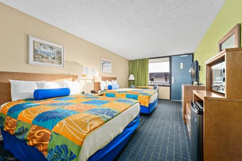 大洋城Harris House by the Beach的酒店客房设有两张床和一台平面电视。