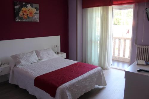 桑亨霍Hotel Fernandez的一间卧室设有一张大床和一个窗户。