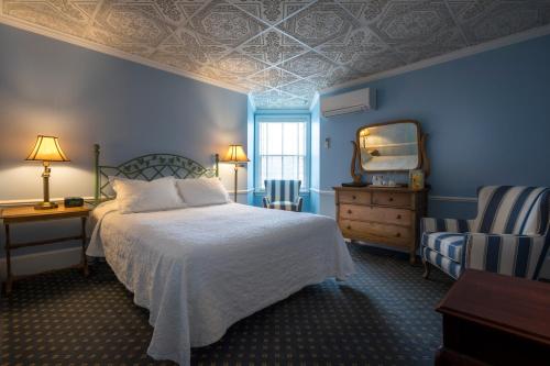 佩托斯基斯塔福德海湾景酒店的一间蓝色卧室,配有一张床和镜子