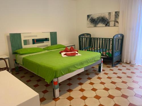 拉卡莱Casa Manni Torre Suda的一间卧室配有一张绿色的床和两张婴儿床