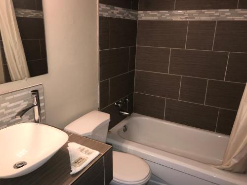 尼亚加拉瀑布彩虹汽车旅馆 - 瀑布景的浴室配有盥洗盆、卫生间和浴缸。