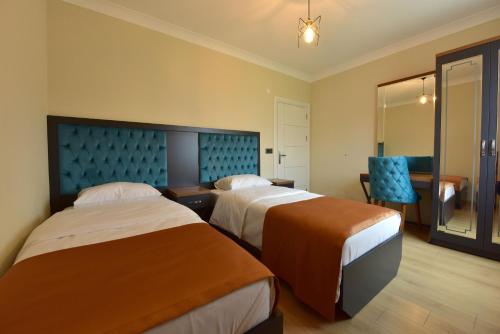特拉布宗İnanlar Airport Residence的酒店客房,配有两张床和椅子