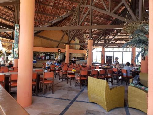 阿奎拉兹Aquaville Resort的一间设有桌椅的餐厅,有人坐在餐厅里