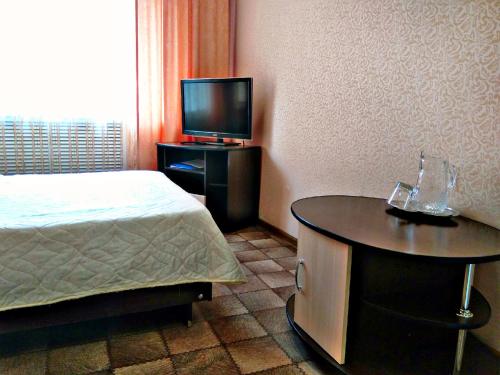 巴尔瑙尔Hotel Kolos的一间卧室配有一张床和一张桌子及电视