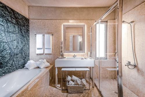 阿齐亚佩拉加蓝湾度假酒店的浴室配有盥洗盆、浴缸和盥洗盆