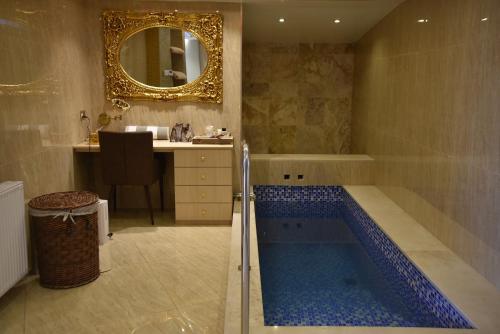 拉纳卡Rimon Cyprus Israeli Kosher Rooms的一间带浴缸、水槽和镜子的浴室