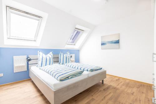 里尔Siedlerstraße的一间卧室配有一张蓝色墙壁和窗户的床