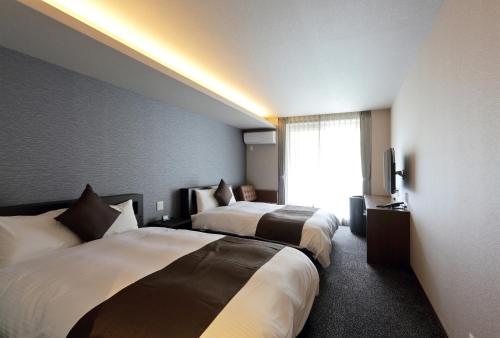 HOTEL PROMOTE HIROSHIMA客房内的一张或多张床位