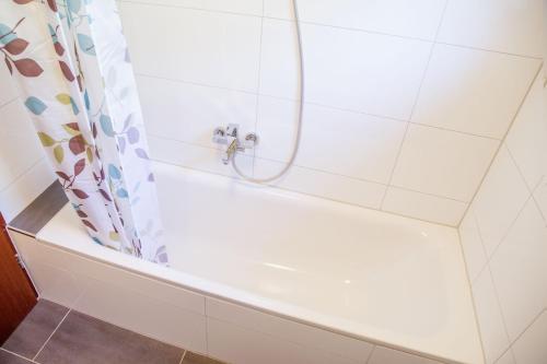 瓦尔德-米谢尔巴赫Casa Susanna的浴室内设有带浴帘的白色浴缸