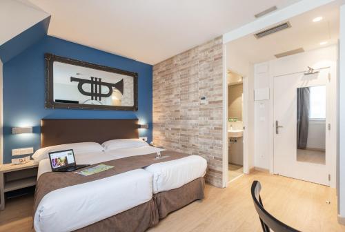 圣塞瓦斯蒂安Casual del Jazz San Sebastián的一间卧室设有一张大床和蓝色的墙壁