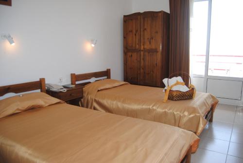 Agia ErmioniMaria Rooms的酒店客房带两张床,座位上有一个篮子