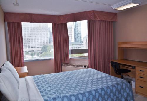 多伦多栗树酒店及会议中心 - 多伦多大学的一间卧室配有一张床、一张书桌和一个窗户。