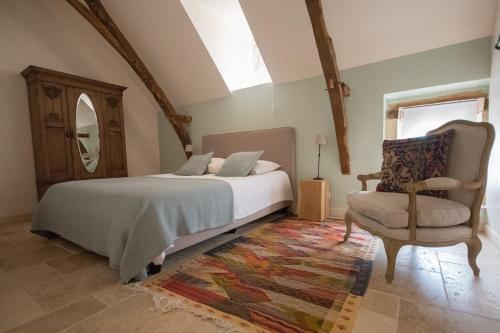 奥瑞阿卡杜佩里戈尔Maison du Cèdre的一间卧室配有一张床、一把椅子和镜子