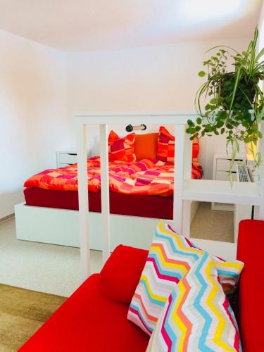 伦斯泰格地区施米德费尔德Pension SPORT-SCHMIEDE的一间卧室配有一张床和一张红色的沙发