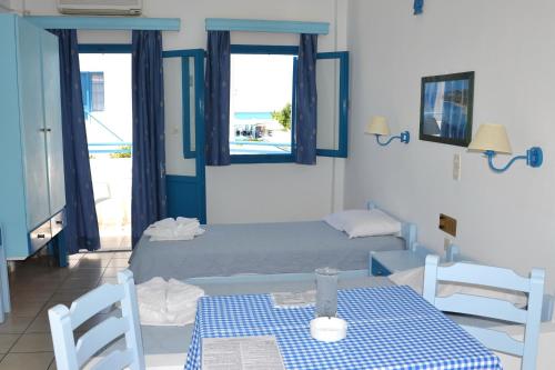 普拉坦斯加丽娜海滩酒店的卧室配有一张床和一张桌子及椅子