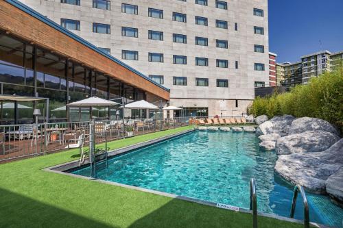巴拉卡毕尔巴鄂门酒店的大楼前的大型游泳池