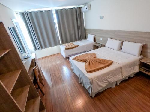巴热Dalle Hotel的铺有木地板的客房内的两张床