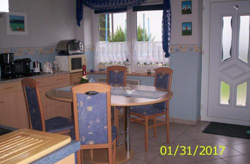 MaltzienFerienhaus-Bender-Rügen的厨房配有木桌、椅子和桌子