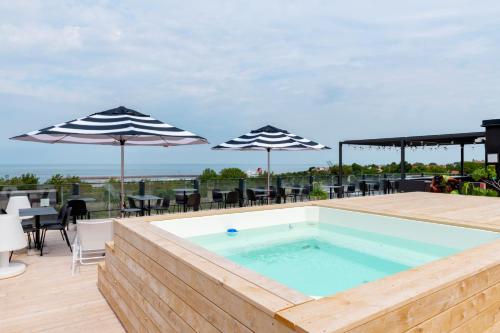 维斯比First Hotel Kokoloko的一个带遮阳伞的甲板上的游泳池