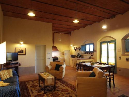 科尔托纳骑士村科尔托纳度假酒店的带沙发和桌子的客厅以及厨房。