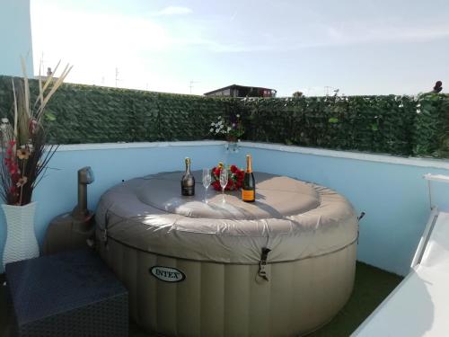 拉卡莱b&b MareSalento的热水浴池内备有2瓶葡萄酒