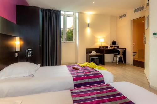马赛圣查尔斯终点酒店的酒店客房配有两张床和一张书桌