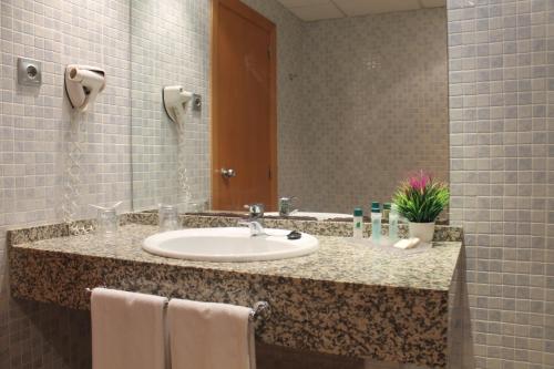 维拉Advise Hotels Reina的一间带水槽和镜子的浴室