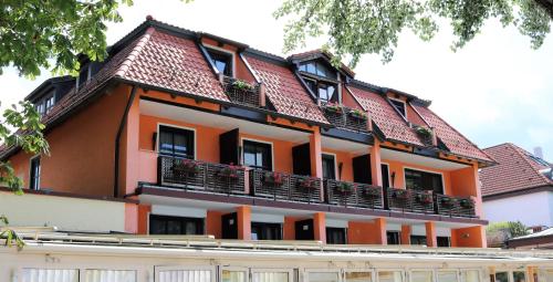 海瑞星阿莫斯Seehotel Pegasus的一座橙色和白色的建筑,有屋顶