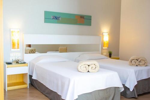 库里提巴Bristol Brasil 500 Curitiba Batel的两张位于酒店客房的床,配有毛巾