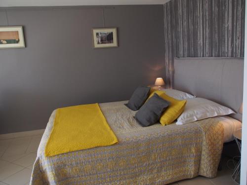 马诺斯克Une Heure Bleue的一间卧室配有一张黄色毯子床