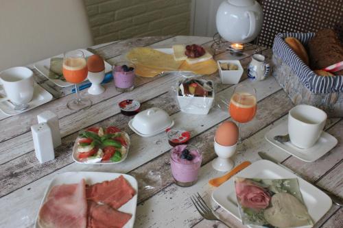 海边的艾格蒙特Kerstins Bed and Breakfast的餐桌,带食物盘和橙汁杯